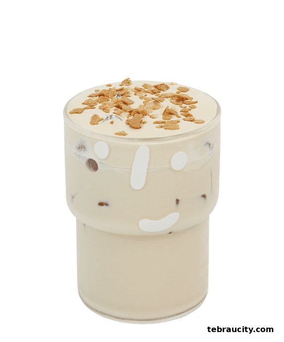 A refreshing iced coffee topped with whipped cream and crunchy cereal in a decorative glass.