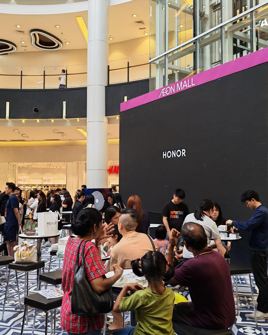 Event staff assisting customers at the HONOR showcase