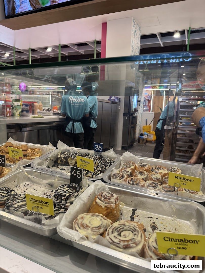 A display of freshly baked Cinnabon cinnamon rolls and minibons in a bakery.