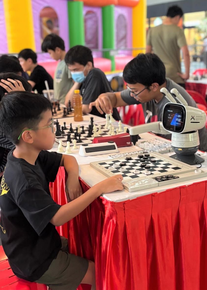 A visitor testing their skills against a specialized chess robot.
