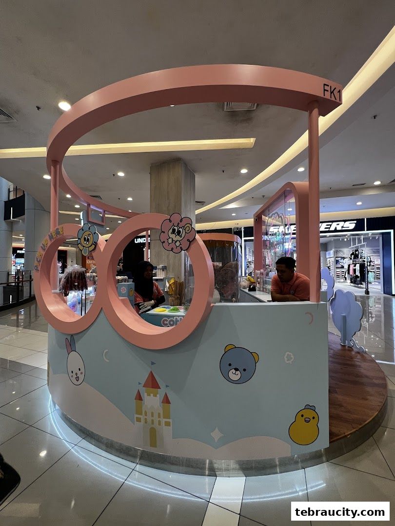 A cute, pastel-themed kiosk selling treats with cartoon characters and a castle design.