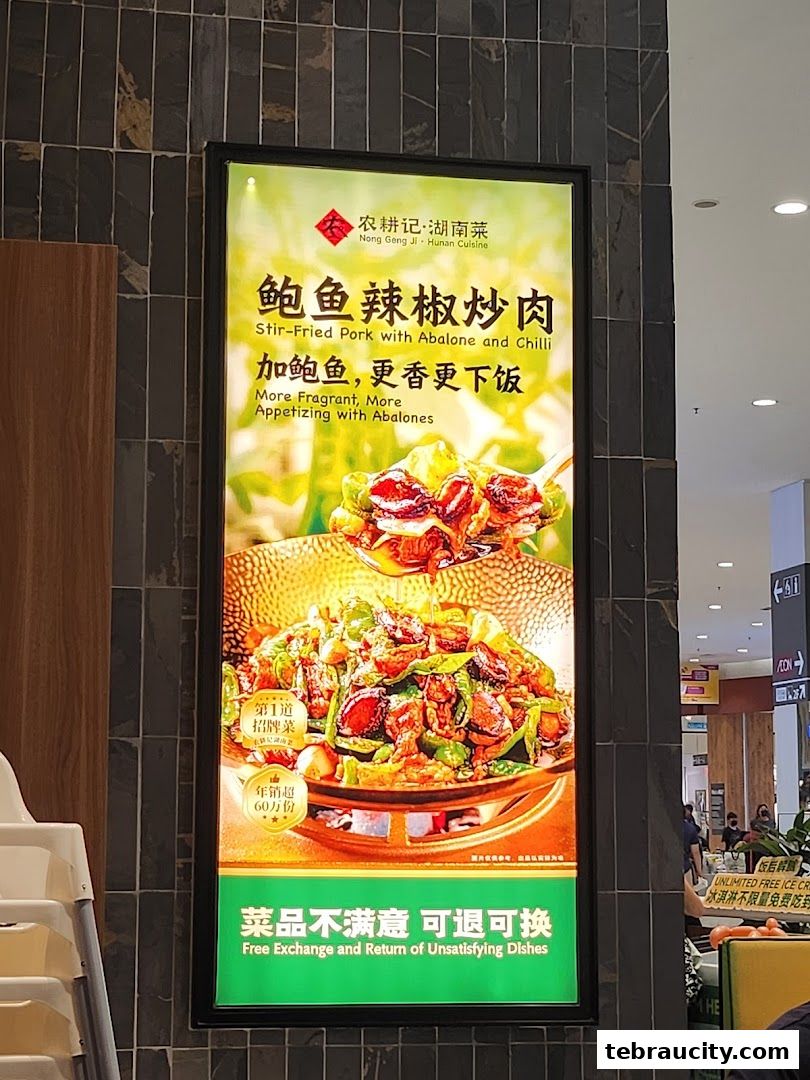 A brightly lit advertisement for Nong Geng Ji Hunan Cuisine, showcasing a stir-fried pork dish.