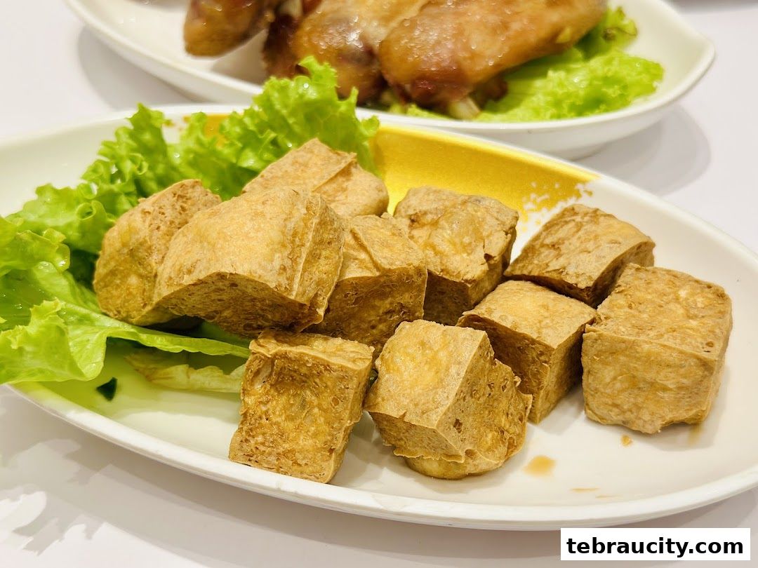 Close-up of crispy fried tofu cubes served with lettuce and a yellow garnish.