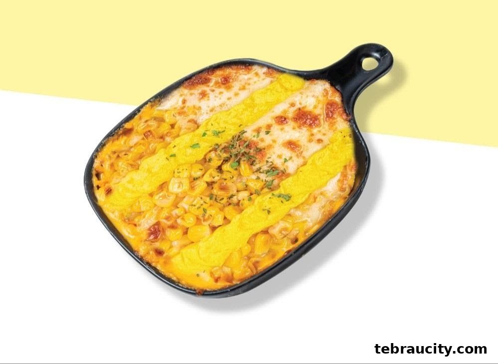 A close-up shot of a cheesy corn dish served in a black baking dish.