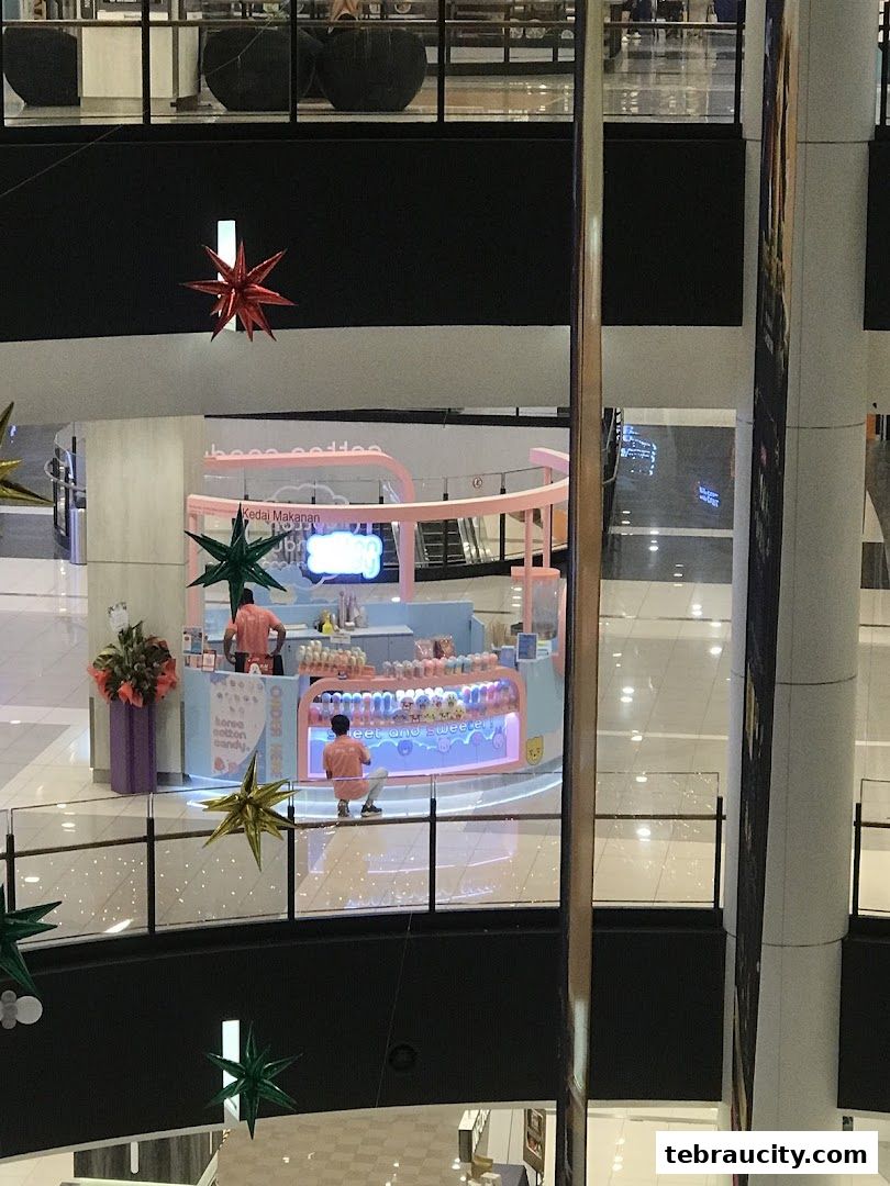 A brightly lit Cotton Candy shop with staff serving customers in a mall.