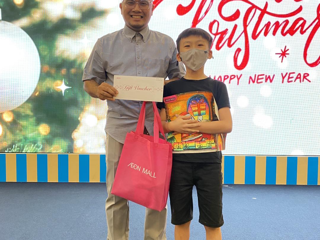 A group of children proudly displaying their finished Christmas-themed artworks