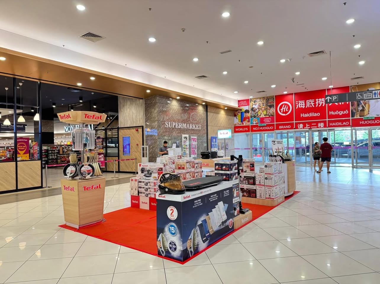 TEFAL staff member demonstrating a product to an interested customer.