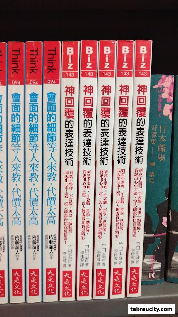 A shelf filled with books, mostly in Chinese and Japanese, with some red and white spines.