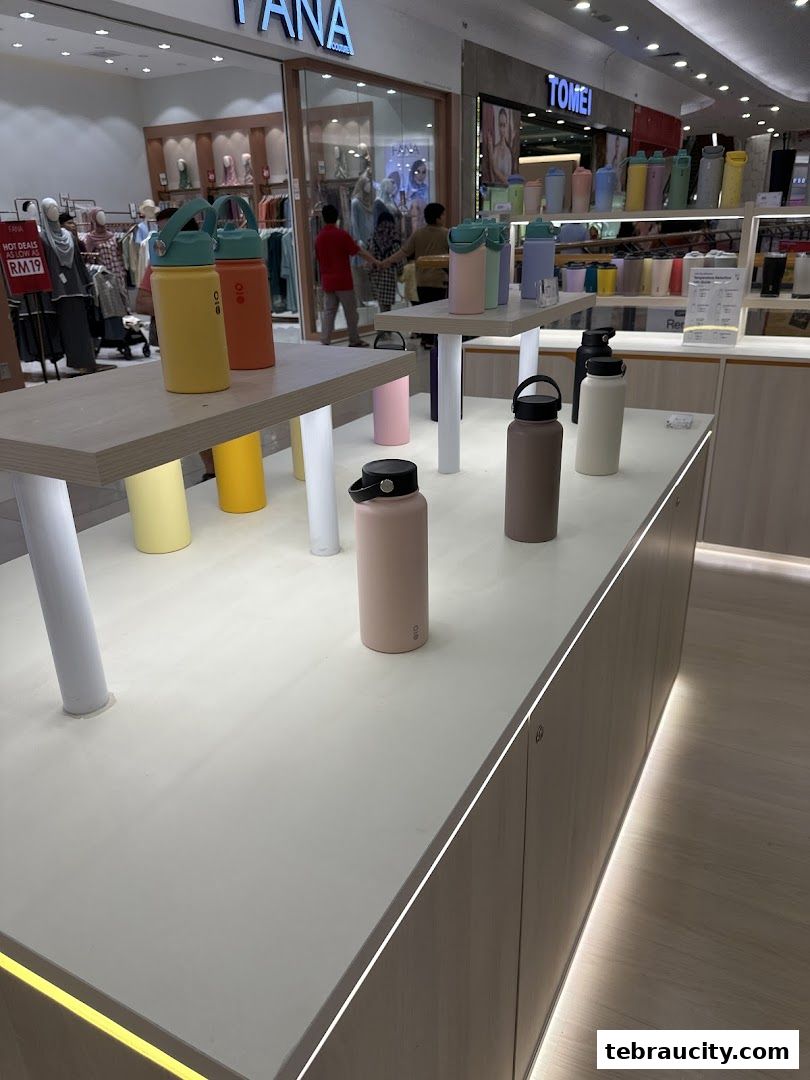 A display of colorful water bottles on shelves inside a retail store.