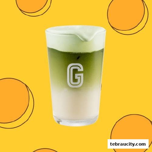 A refreshing matcha latte with cream cheese foam in a glass with the Gigi Coffee logo.