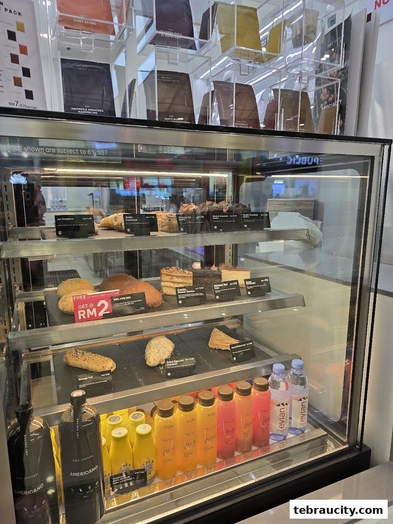 A display case filled with coffee, pastries, juices, and bottled water at HWC Coffee.