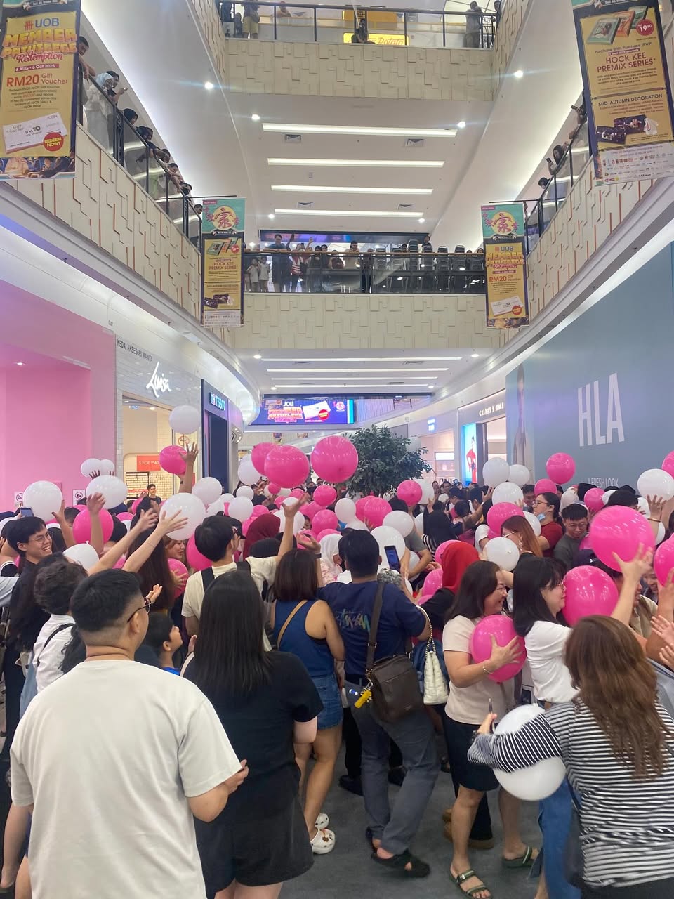 Joyful participants reaching for balloons at AEON MALL Tebrau City