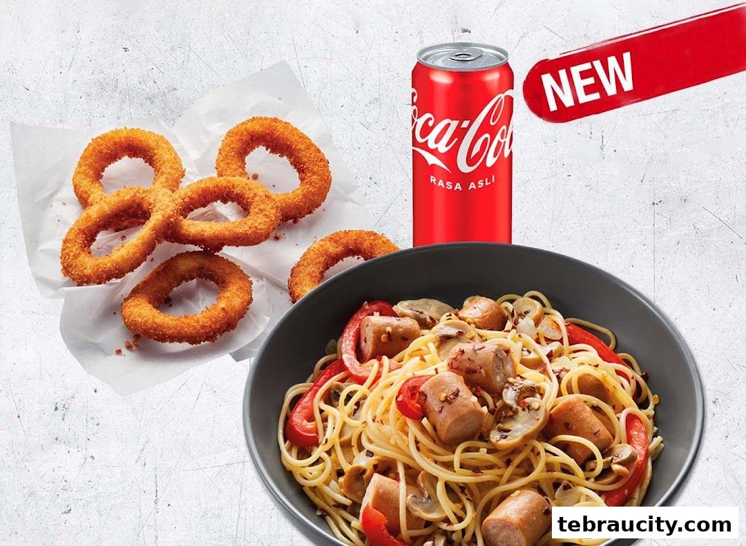 A bowl of spaghetti with sausage and vegetables, onion rings, and a Coca-Cola can.