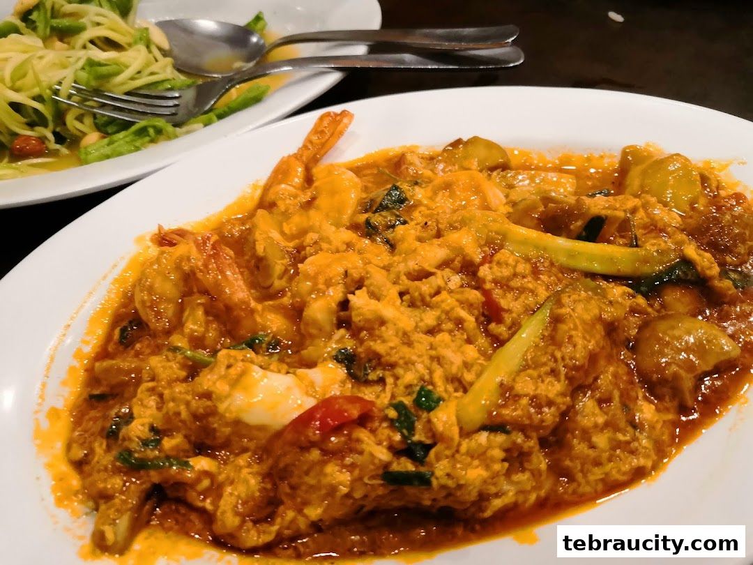 A close-up of a delicious stir-fried shrimp dish with a side of green salad.