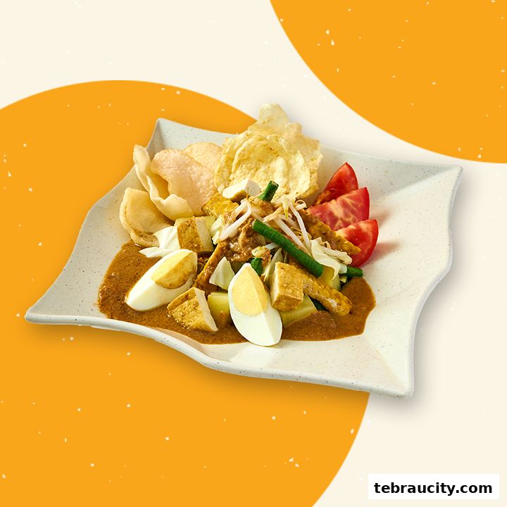A plate of Gado-Gado with peanut sauce, boiled eggs, tofu, vegetables, and crackers.