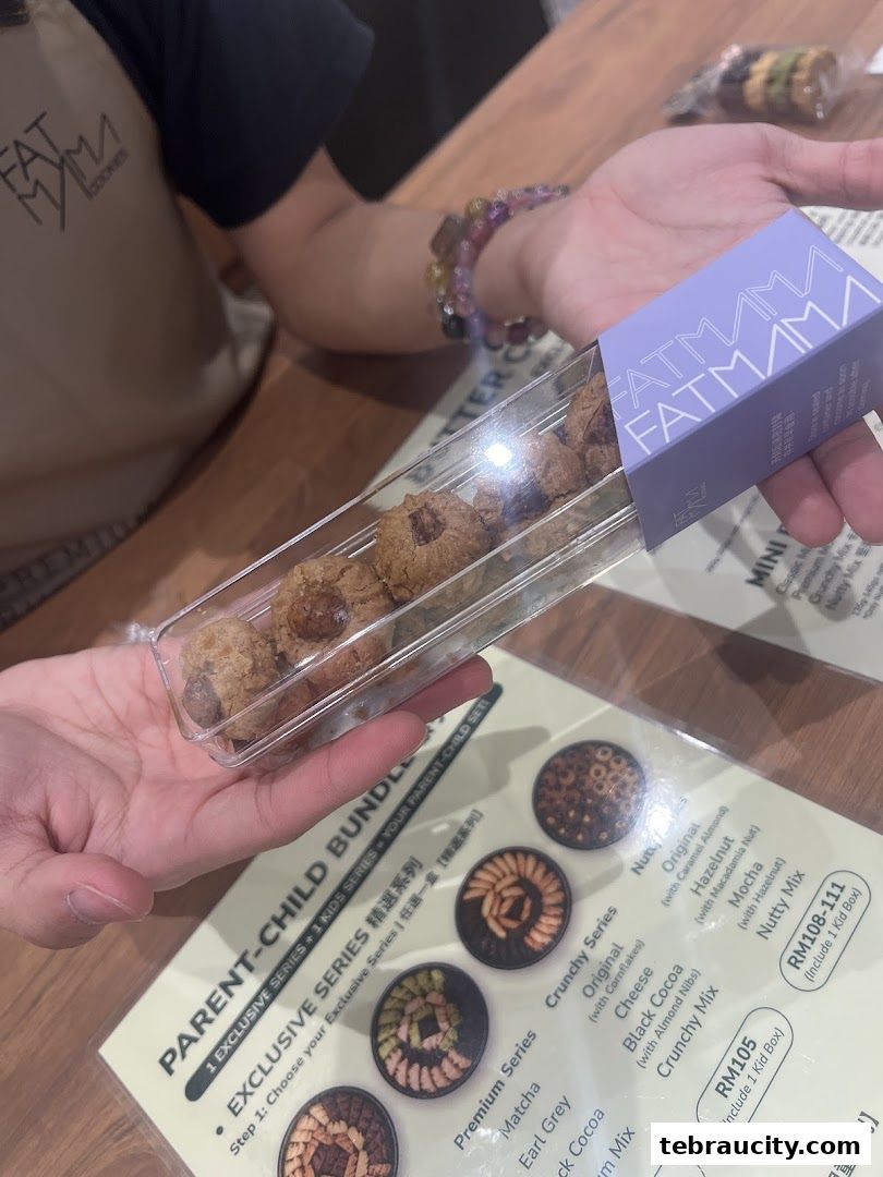 A person holds a box of Fatmama cookies with a menu showing various cookie options.