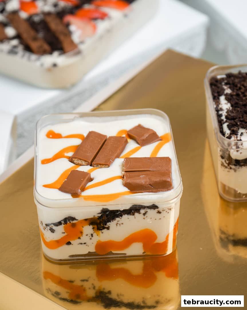 Close-up of layered desserts in clear plastic containers, topped with chocolate and caramel.