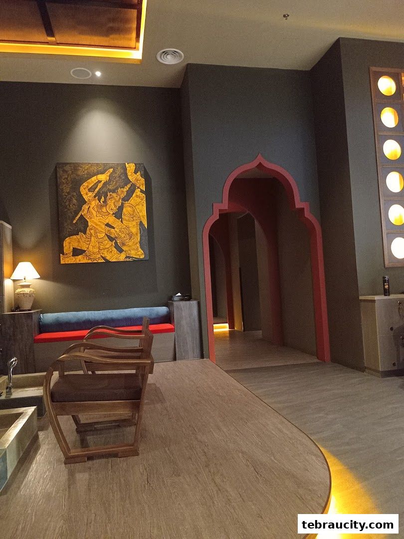 Interior of a spa with a chair, artwork, and arched doorways.