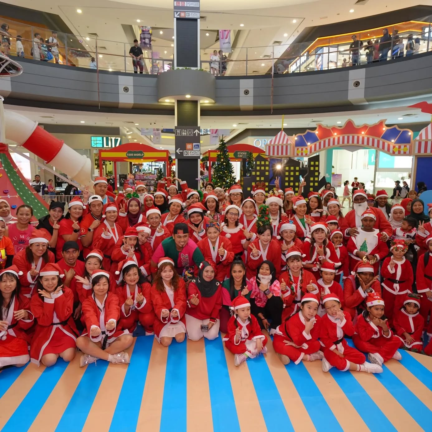 Participants in Santa costumes celebrating at AEON MALL's historic event.