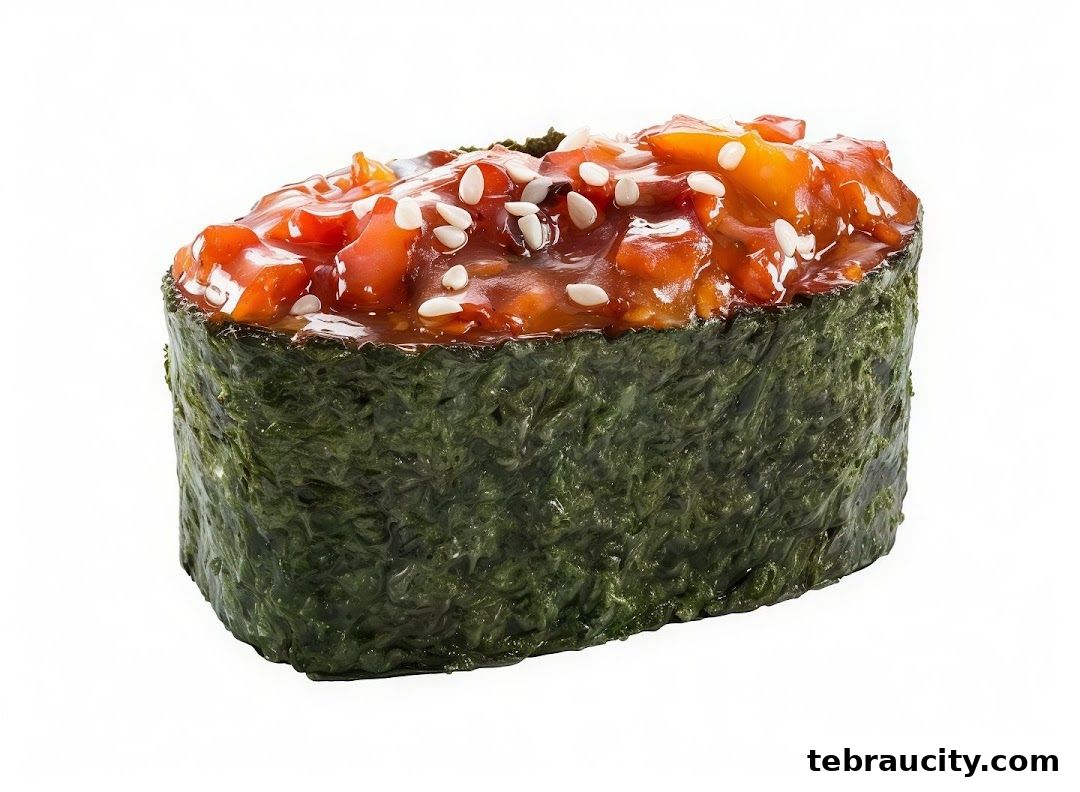 A close-up of a spicy tuna gunkan maki sushi roll with sesame seeds.