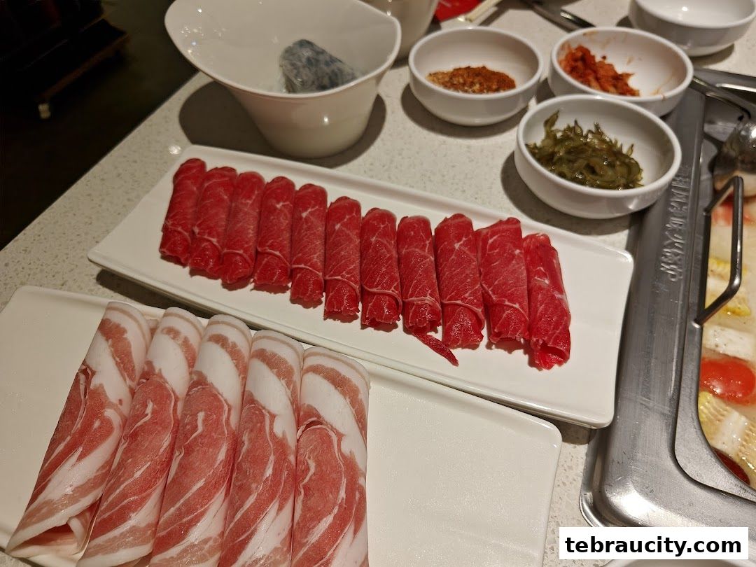 Plates of thinly sliced beef and pork belly ready for hot pot cooking.