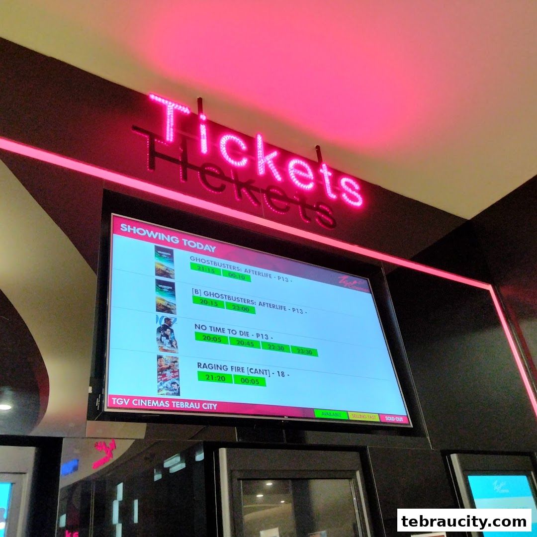 A digital display showing movie showtimes for TGV Cinemas Tebrau City.