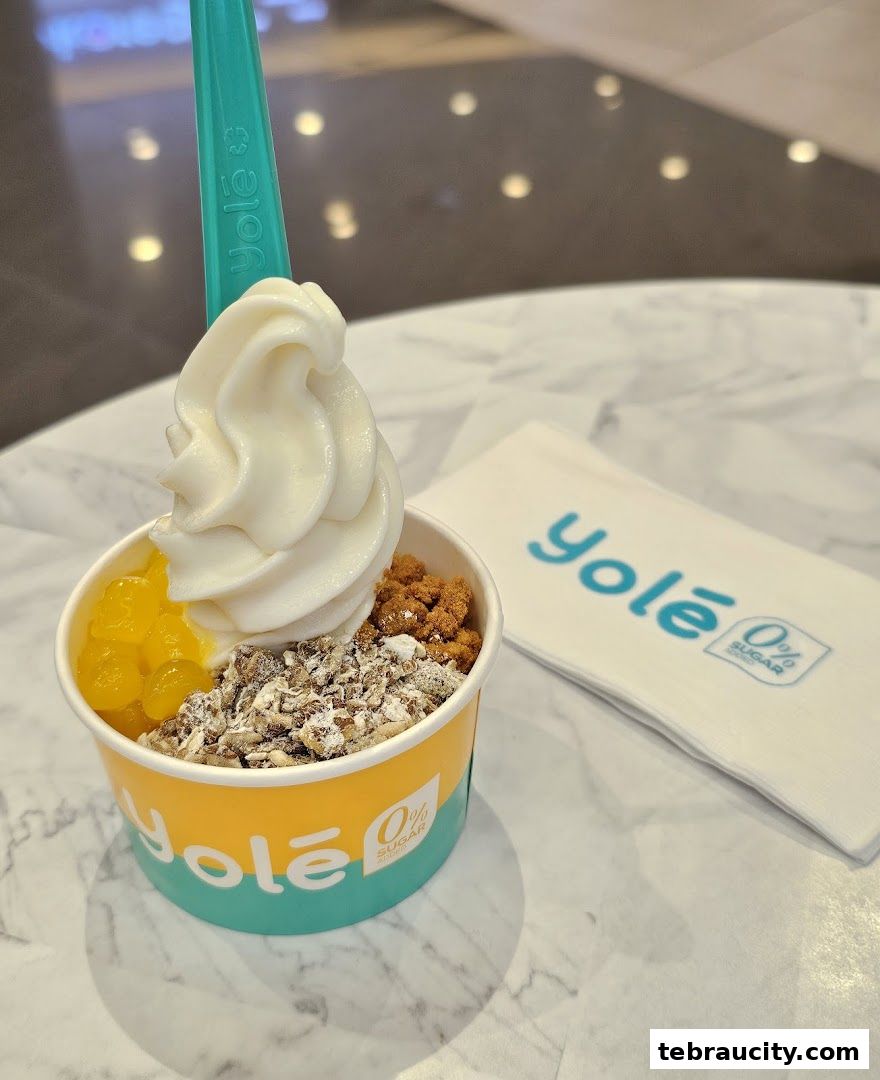 A cup of frozen yogurt with toppings and a Yolé branded napkin.