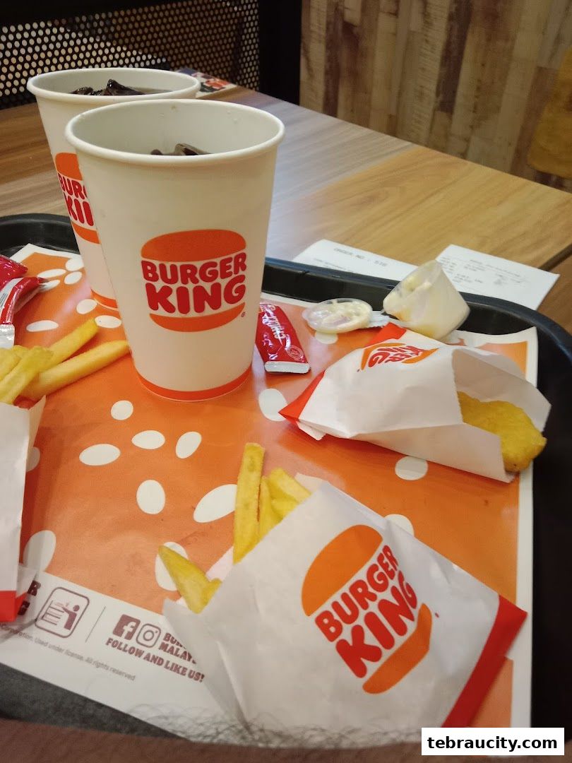 Burger King meal with drinks, fries, and a burger on a tray.