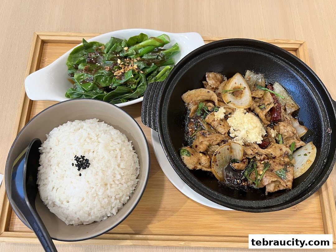 A delicious meal featuring stir-fried meat with onions and vegetables, served with rice.