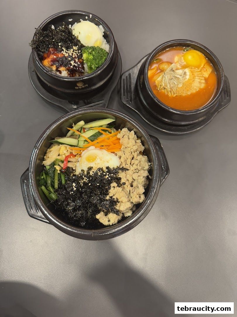Three Korean dishes served in stone bowls, featuring rice, vegetables, egg, and meat.