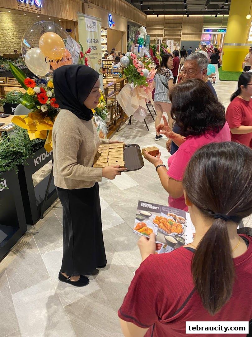 A staff member offers samples of food to customers at a KyoChon1991 store.