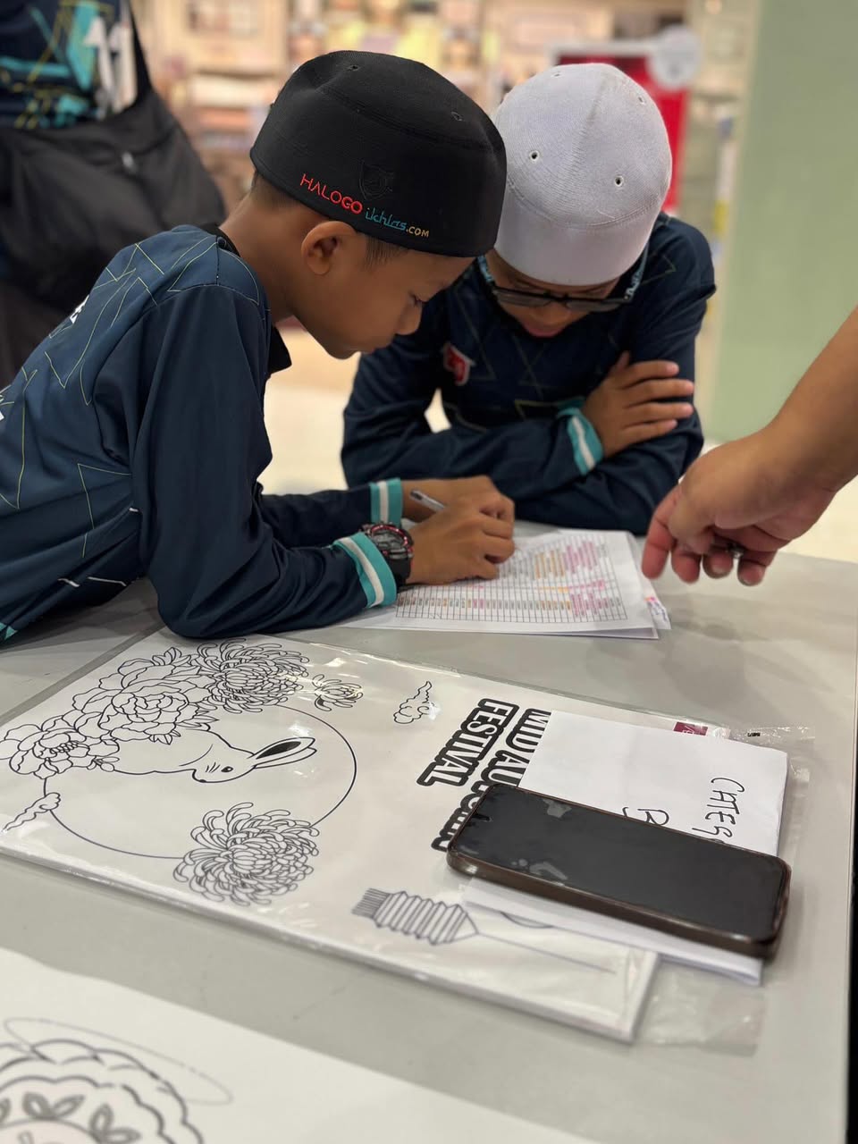 A child proudly showing their colorful drawing at the contest