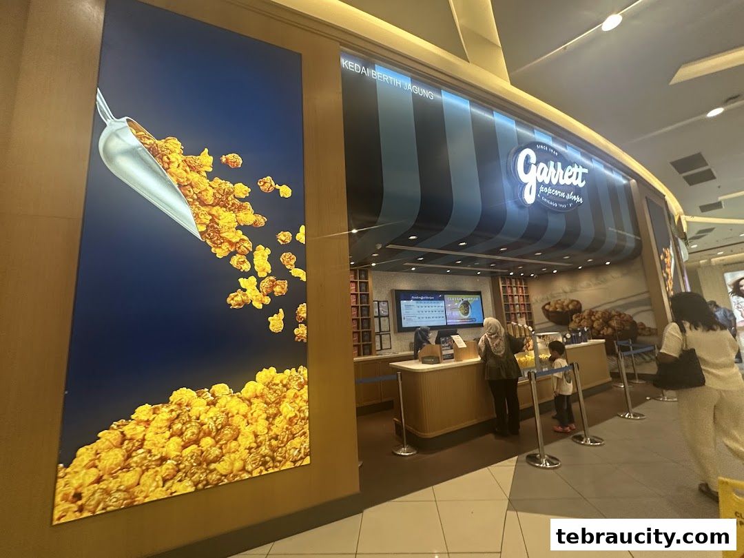 The exterior of Garrett Popcorn Shops with a large popcorn graphic and customers at the counter.