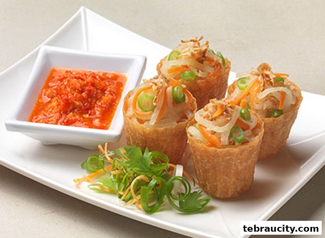 Four crispy fried parcels filled with vegetables and served with chili sauce and garnish.