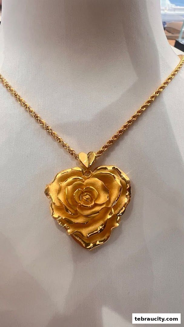 A close-up of a gold rose pendant necklace displayed on a mannequin.