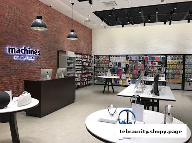 Interior view of a Machines Apple Reseller Store with products displayed on shelves and tables.