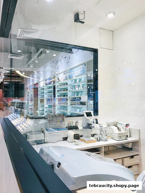 Interior view of an optical shop with display shelves filled with eyeglasses and optical equipment.