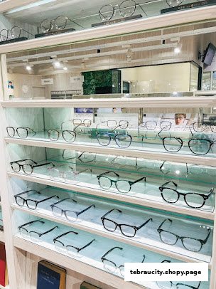 A display of various eyeglasses on shelves inside an optical shop.