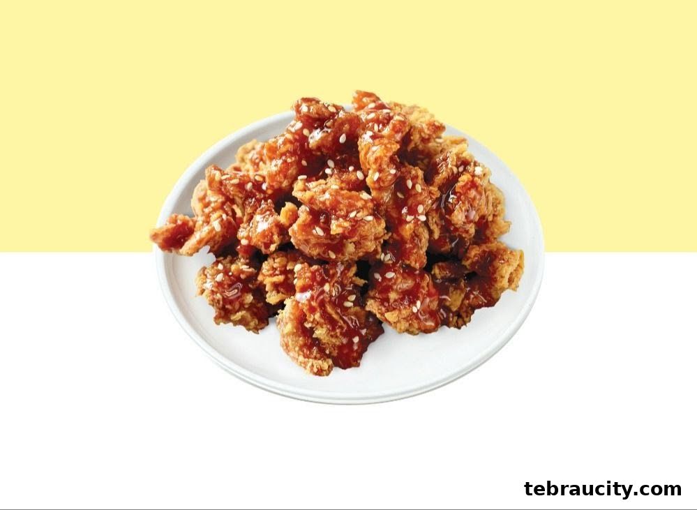 A plate of crispy fried chicken coated in a glossy sauce and sprinkled with sesame seeds.