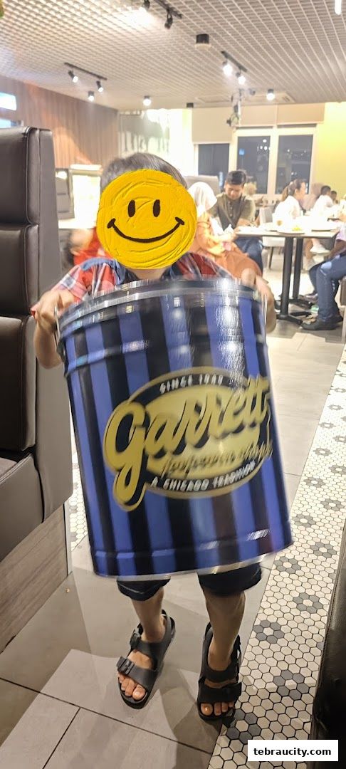 A child holds a large tin of Garrett Popcorn inside the shop.
