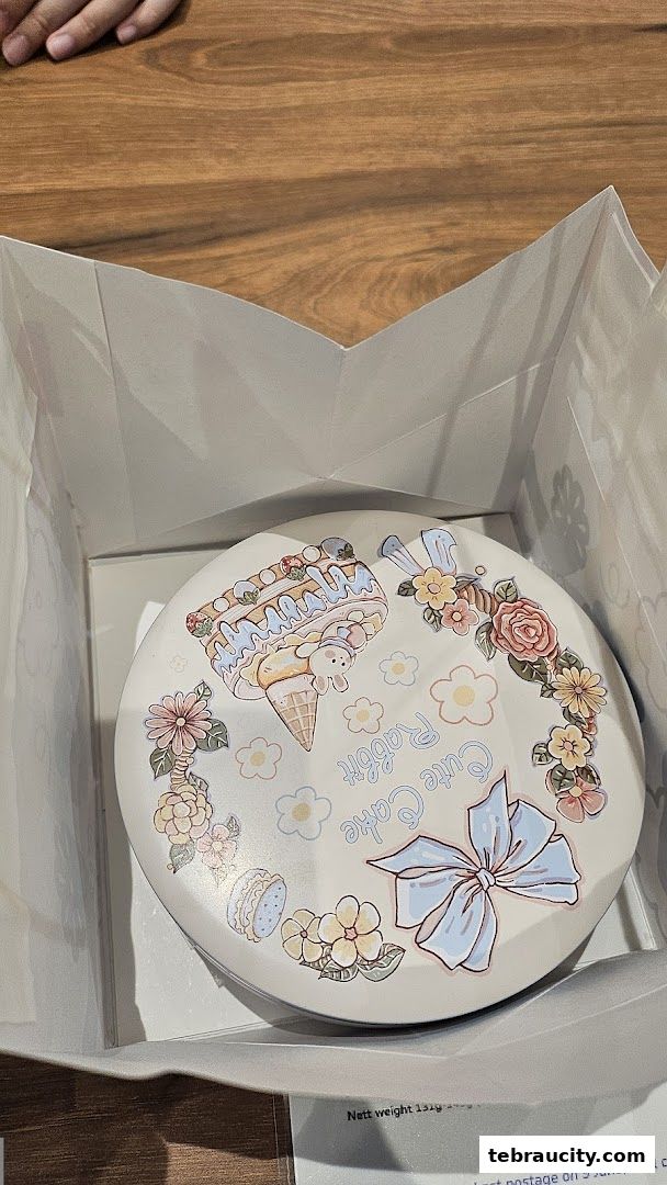 A round cake box with cute cartoon designs of ice cream, rabbits, flowers, and a bow.