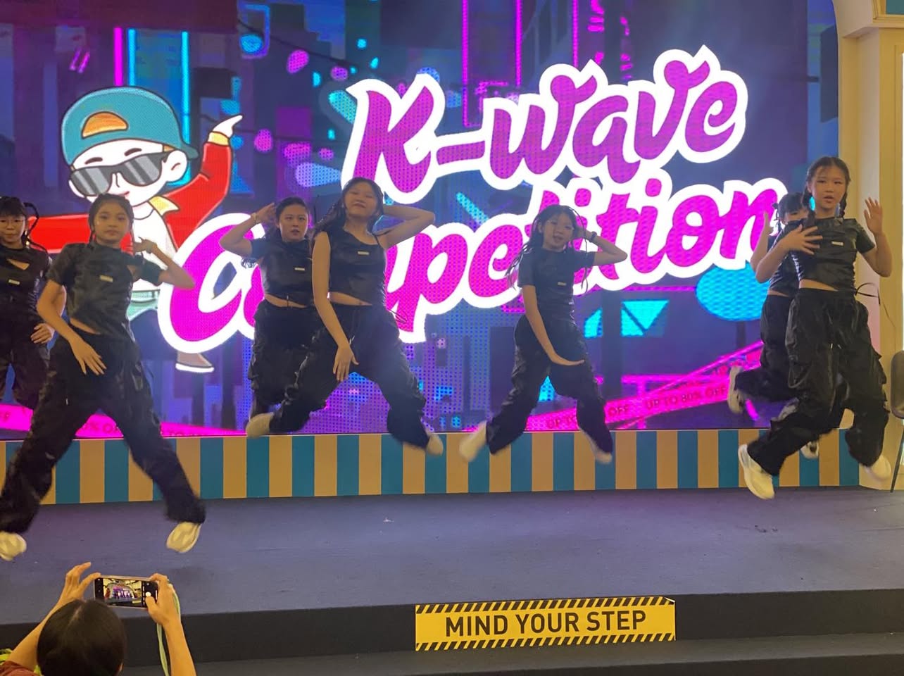 Performers showcasing their talent at the K-Wave Dance Competition