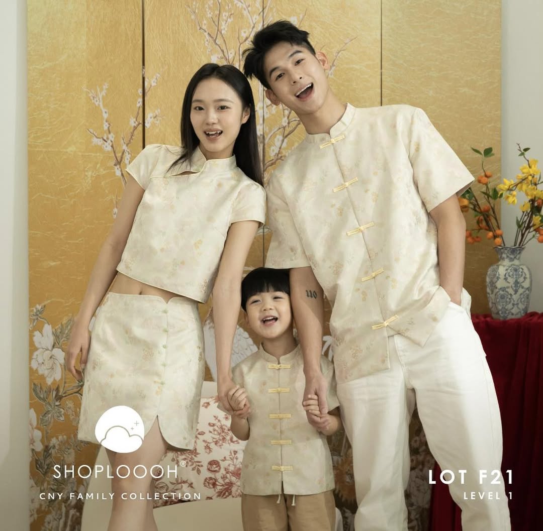 A family, including a pet, celebrating Chinese New Year with festive attire and decorations.