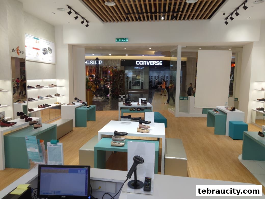 Interior view of a modern shoe store with displays of various footwear and a checkout counter.
