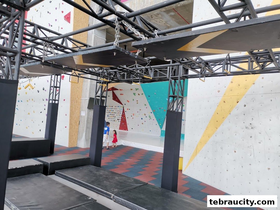 Indoor climbing gym with colorful walls and obstacle course elements.