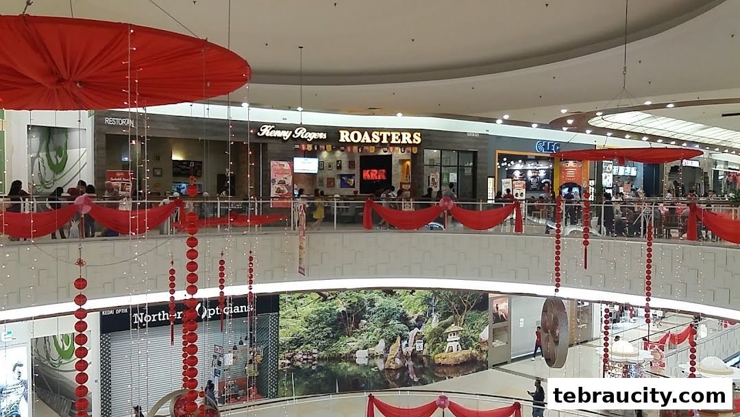A view of Kenny Rogers Roasters restaurant and other shops in a mall, decorated with red lanterns.