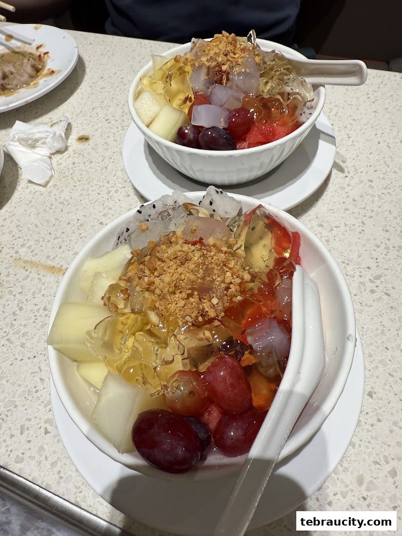 Two bowls of colorful fruit and jelly desserts topped with crushed peanuts.