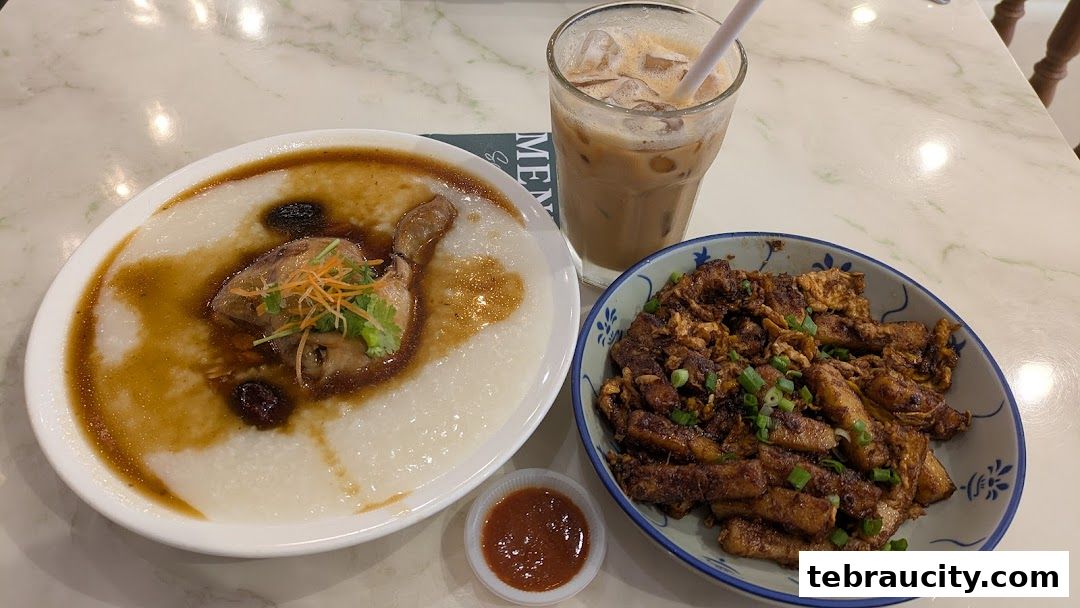 A bowl of congee with chicken, a plate of fried radish cake, and a glass of iced coffee.