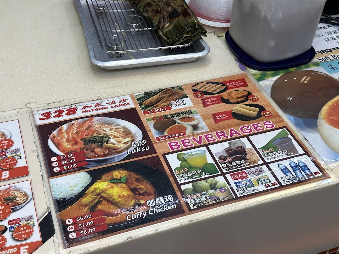A detailed menu board for 328 Katong Laksa, showcasing their signature dishes, sides, and beverages.