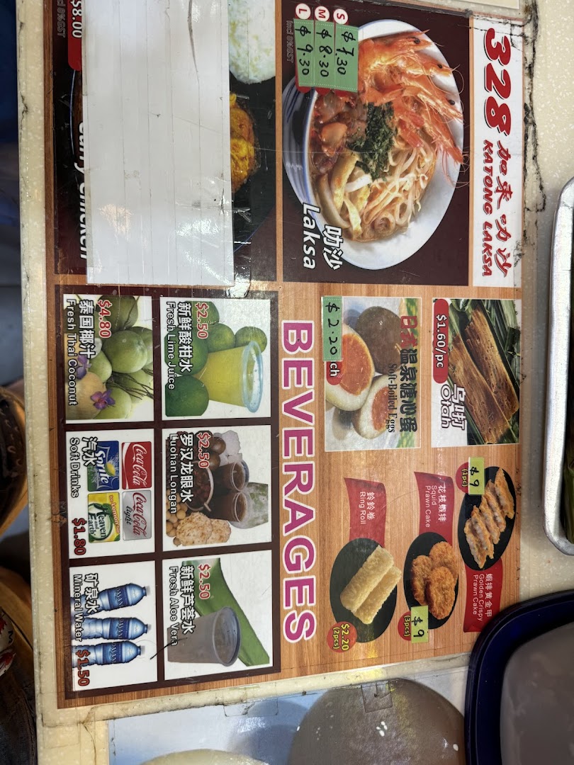 A detailed menu board displaying various Laksa dishes, side orders, and beverages with prices.